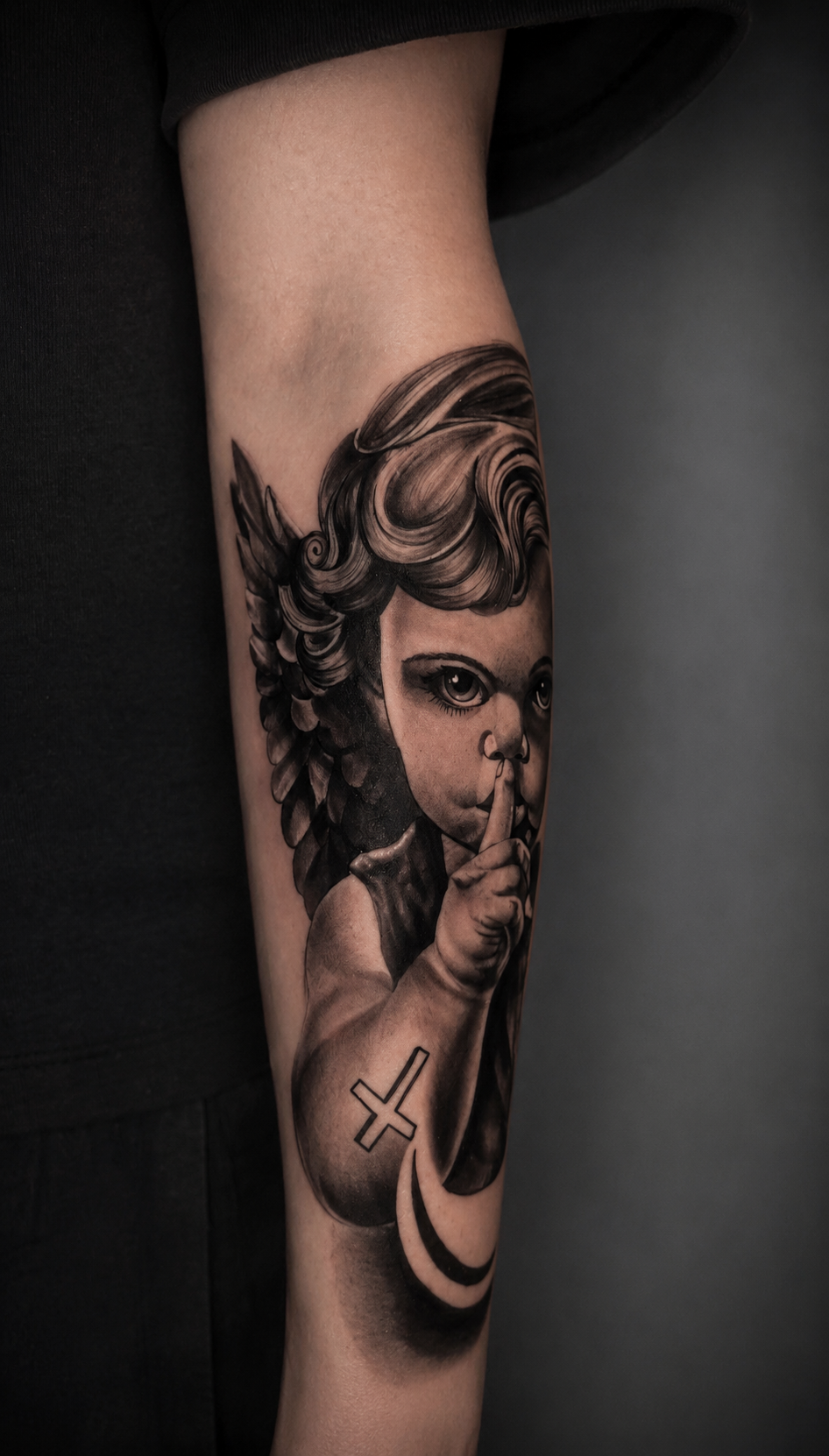 Black and grey cherub forearm tattoo by Rondon Neto
